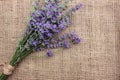 Bunch of lavender flowers on burlap fabric texture.