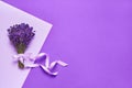 Bunch of lavender flowers decorated with ribbon on purple background. Top view, copy space Royalty Free Stock Photo