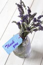 Bunch of lavender in a glass lantern jar, with thank you written on a blue gift label.