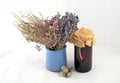 Bunch of lavender, sage and Kermek in purple vase next to a jar