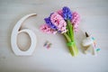 Bunch of light pink and purple hyacinths and white wooden number six. Sixth birthday or anniversary concept