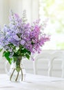 Bunch lilac flowers in vase on table