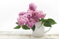 Bunch lilac in vase on wooden table