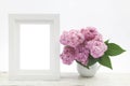 Bunch lilac in vase on wooden table and white frame mock up