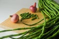 A bunch of long beans, long beans cut into short pieces and some red onion seeds Royalty Free Stock Photo