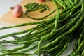 A bunch of long beans, long beans cut into short pieces and some red onion seeds Royalty Free Stock Photo