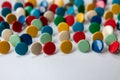 Bunch of many colorful thumbtacks as multi-color office supply metal pushpins circles in yellow, green, blue, red and white desk Royalty Free Stock Photo