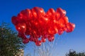 bunch of many red balloons in shape of a heart on the background of blue sky Royalty Free Stock Photo