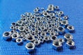 a bunch of metal nuts of different diameters on a blue background Royalty Free Stock Photo