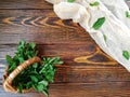 bunch of mint in a small wicker basket on old burnt wooden background Royalty Free Stock Photo