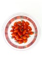 Bunch of Napa grape cherry tomatoes in water inside a clear bowl, on white background Royalty Free Stock Photo