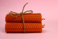 bunch of natural handmade candles made of wax on a pink background Royalty Free Stock Photo