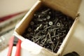 A bunch of new black self-tapping screws in a box Royalty Free Stock Photo