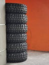 A bunch of new pickup truck rubber tyres stack together on concrete floor.