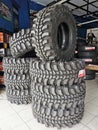 A bunch of new pickup truck rubber tyres stack together on concrete floor.