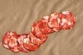 Bunch Of Nine Pork Salami Slices Set On Crumpled Striped Manila Brown Kraft Paper