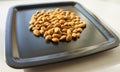 A bunch of nuts of almonds on a black plate. Close-up photo