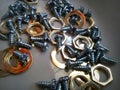 A bunch of nuts, bolts and wall clock rings strewn over the floor