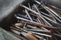 A bunch of old and rusted metallic nails in the box