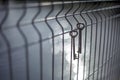 A bunch of old vintage metal door keys hanging on a wire fence with a blurred background and sun highlights on the water Royalty Free Stock Photo