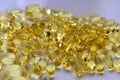 Bunch of omega 3 fish liver oil capsules in pile. Close up of big golden translucent pills texture. Healthy every day nutritional