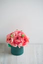 Bunch of pale pink ranunculus persian buttercup light background, wooden surface. green box Royalty Free Stock Photo