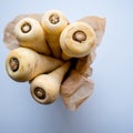 A bunch of parsnips in a cup with baking paper.