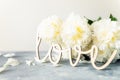 Bunch of peonies in the vase and vintage letters LOVE Royalty Free Stock Photo