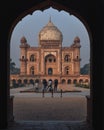 A bunch of photography students standing and taking picture in-front of safdarjung tomb memorial at winter morning