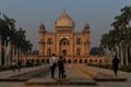 A bunch of photography students standing and taking picture in-front of safdarjung tomb memorial at winter morning
