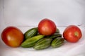 A bunch of Pointed Gourd or parwal and red tomato thes behind the white background