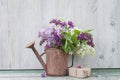 Bunch of purple and white lilacs in the old watering can and hand made gift box Royalty Free Stock Photo