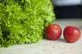 Bunch of raw organic green frisee salad and two tomatoes