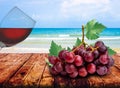 Bunch red grape on old wooden table with leaves and half a glass of red wine Royalty Free Stock Photo
