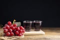 A bunch of red grapes with red grape juice in a glass placed on a wooden table or red wine, delicious natural healthy juice drink Royalty Free Stock Photo