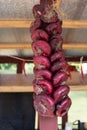A bunch of red onions, a bulb of flat, round onions tied into a long braid. Autumn harvest of vegetables. Spanish variety of sweet