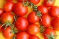 A bunch of red ripe tomatoes lie on a yellow background. Royalty Free Stock Photo