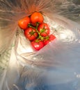 A bunch of red tomatoes packed in plastic
