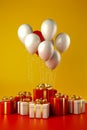 Bunch of red and white balloons and presents on red background with yellow wall