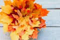 A bunch of red and yellow dry autumn maple leaves and fall twigs on a blue wooden background. Royalty Free Stock Photo