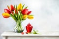 Bunch red and yellow tulip flowers in glass vintage vase on rustic wooden table Royalty Free Stock Photo