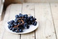 Bunch of ripe blue grapes on a light wooden background