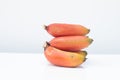 Bunch of ripe Cavendish banana or red bananas fruit on white table and white background Royalty Free Stock Photo