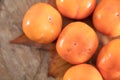 A bunch of ripe crispy persimmons on a yellow leaf