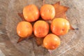 A bunch of ripe crispy persimmons on a yellow leaf