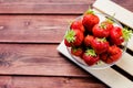 A bunch of ripe Juice strawberries in a bowl on wooden table.Fresh strawberries in basket, freshly harvested fruits on Royalty Free Stock Photo