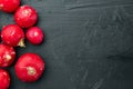 Bunch of ripe radishes, on black background, top view flat lay , with copyspace  and space for text Royalty Free Stock Photo