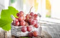 bunch of ripe red grapes in a small basket on the table in the house under the rays of the sun. Large ripe grapes are Royalty Free Stock Photo