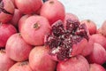 A bunch of ripe red pomegranates on the street in winter. One of the fruits is cut in half. Visible grains and bones Royalty Free Stock Photo