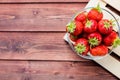 A bunch of ripe Juice strawberries in a bowl on wooden table.Fresh strawberries in basket, freshly harvested fruits on Royalty Free Stock Photo